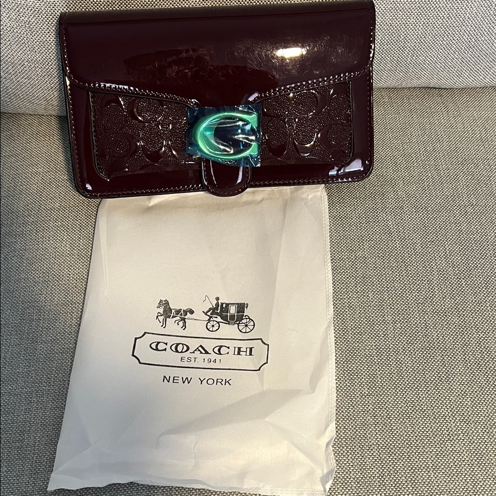 Coach Dark Red Patent Leather Wallet with Blue Clasp.